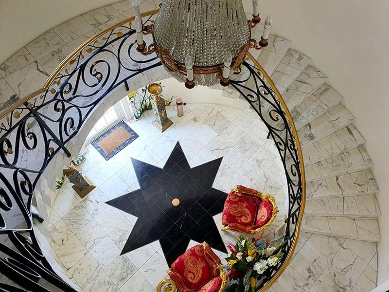 
a staircase that has a bunch of pieces of art on it at Ocean West Boutique Hotel in Nassau
