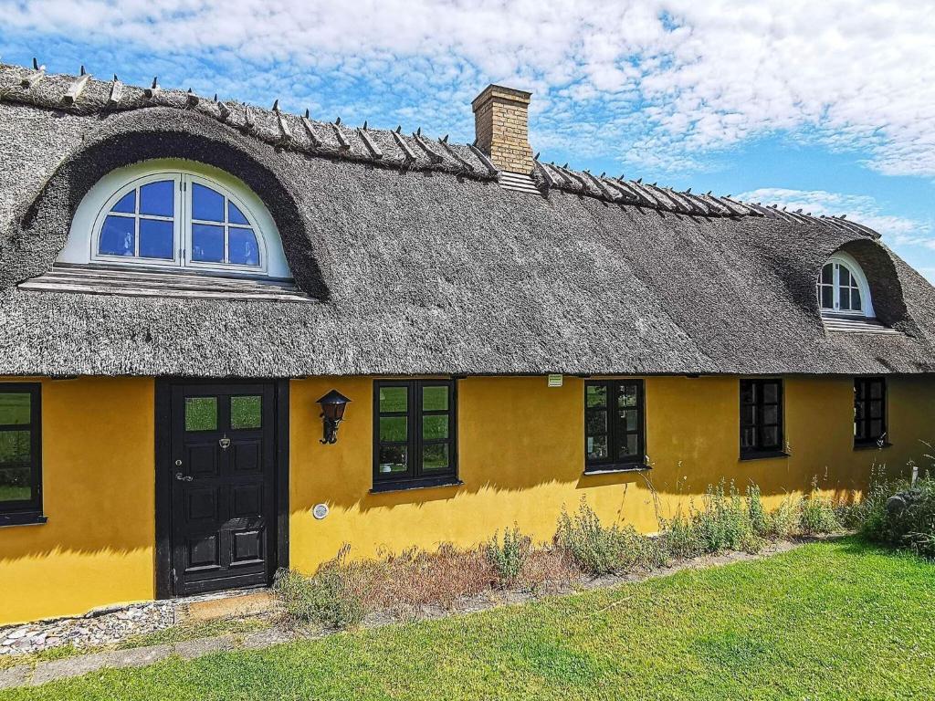 a yellow house with a thatched roof at Holiday home Rudkøbing XI in Rudkøbing