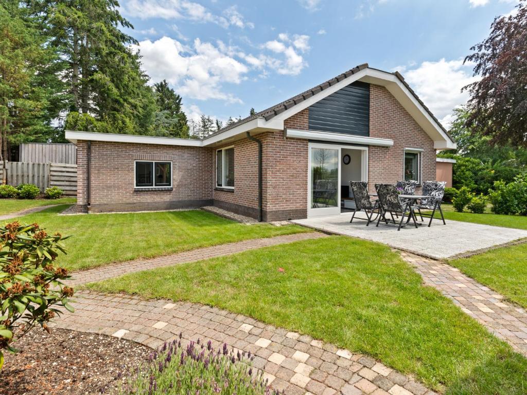 a brick house with a patio and grass at Quaint Holiday Home in Putten with Garden in Putten