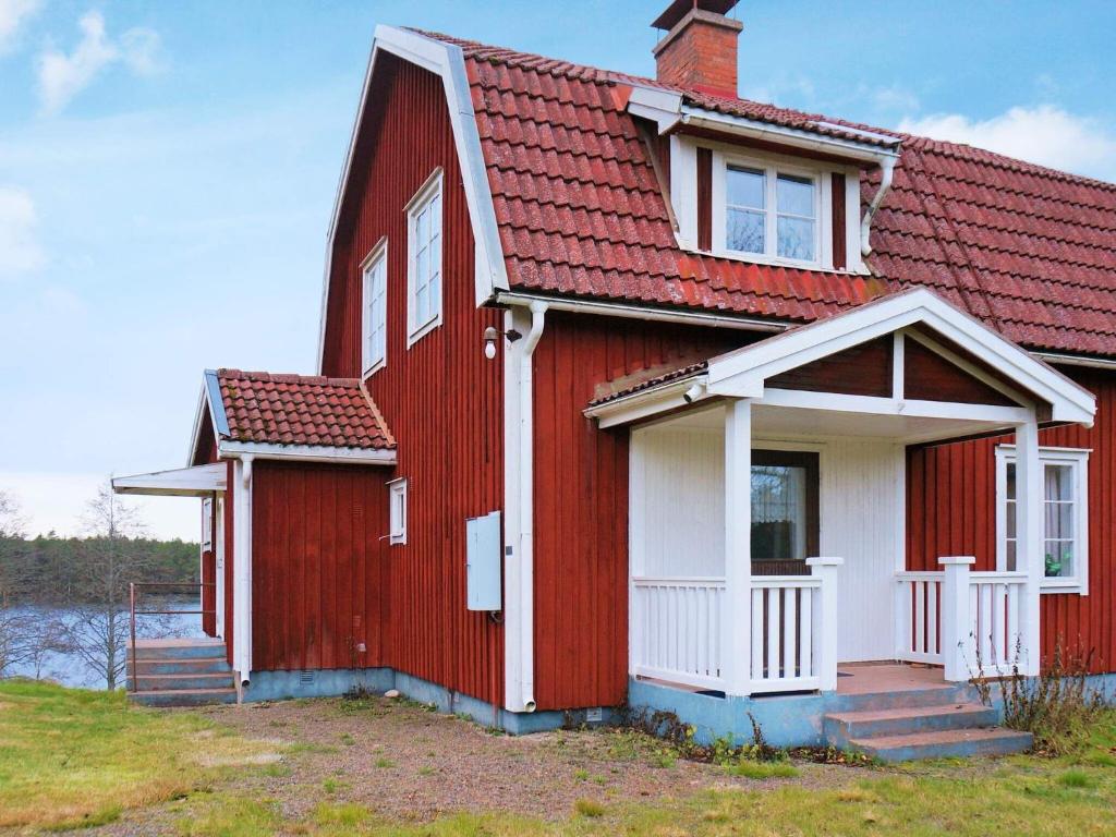 une maison rouge avec un toit rouge dans l'établissement 6 person holiday home in BRUZAHOLM, à Bruzaholm