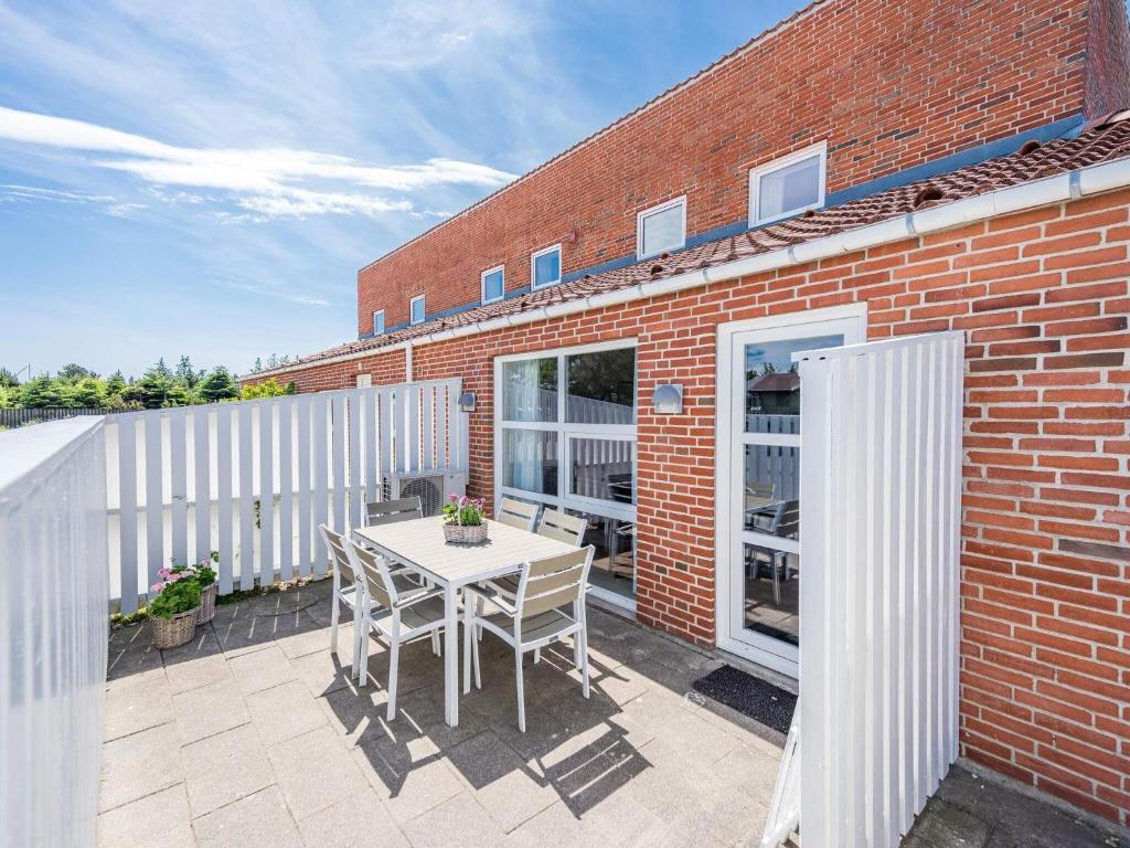 eine Terrasse mit einem Tisch und Stühlen auf einem Backsteingebäude in der Unterkunft Modern Beach Retreat in Blavand-By Traum in Blåvand