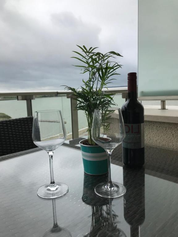 a table with two wine glasses and a bottle of wine at Panorama Apartman in Velence