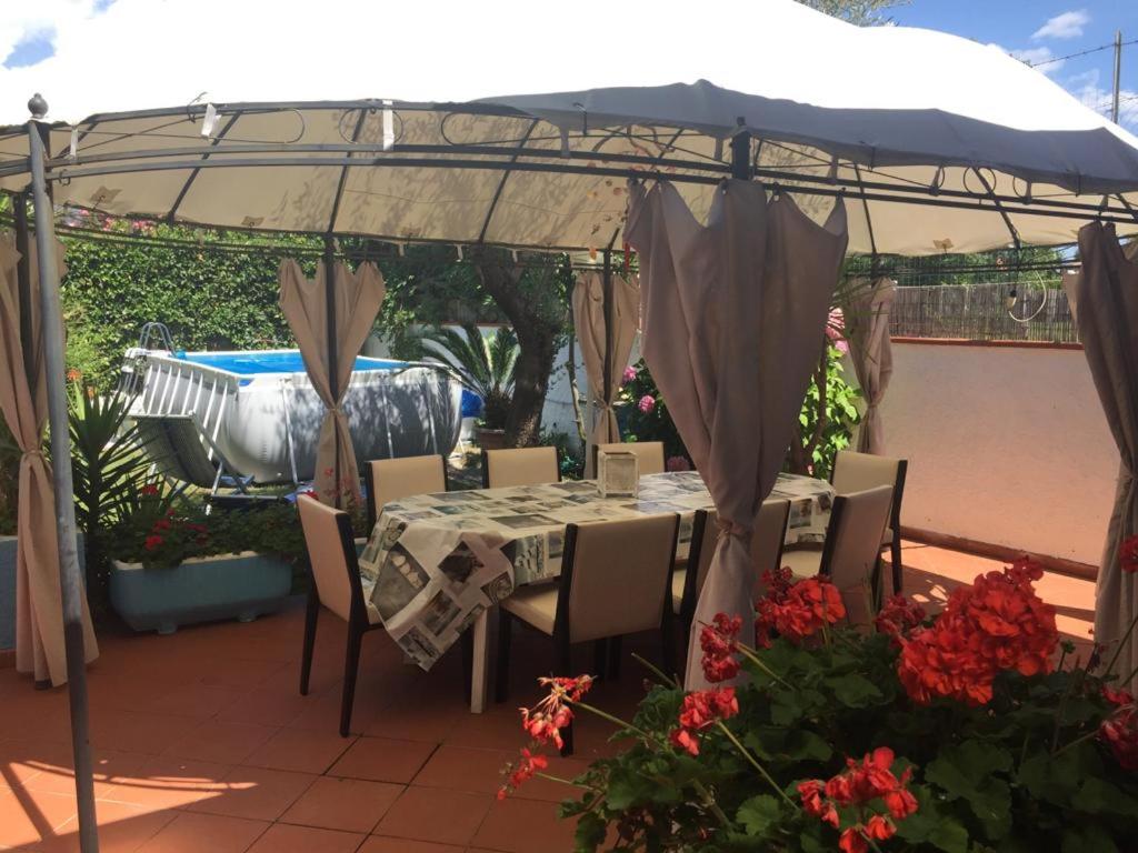 a table and chairs under an umbrella on a patio at La villa dell'ammiraglio in Forte dei Marmi