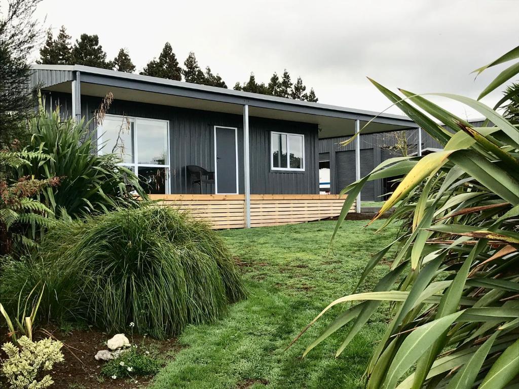 a modern house with a yard with grass at Maungatautari Outlook Cambridge in Cambridge