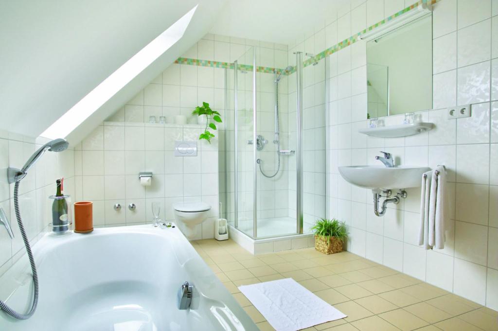 a bathroom with a tub and a sink and a toilet at Landgasthof & Landhotel Wild in Haunwang