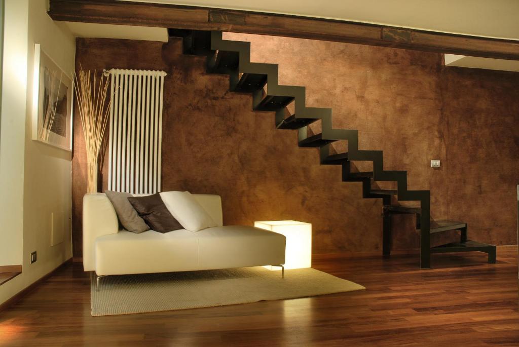 a living room with a white couch and a staircase at B&B Terres D'Aventure Suites in Turin