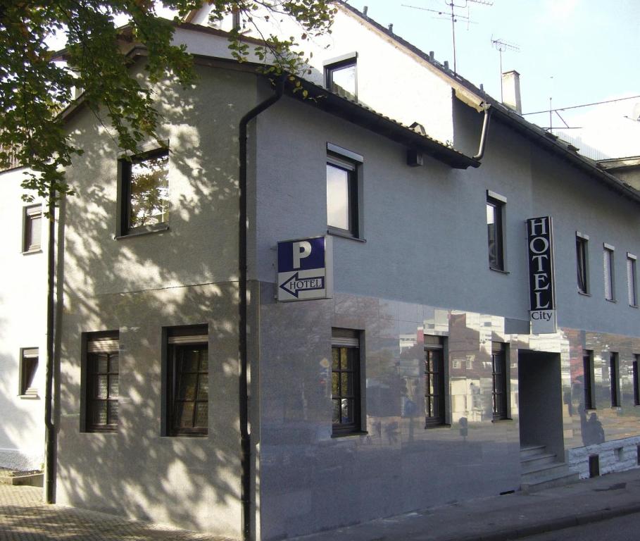 un edificio blanco con una señal de estacionamiento en el costado en City Hotel, en Ludwigsburg