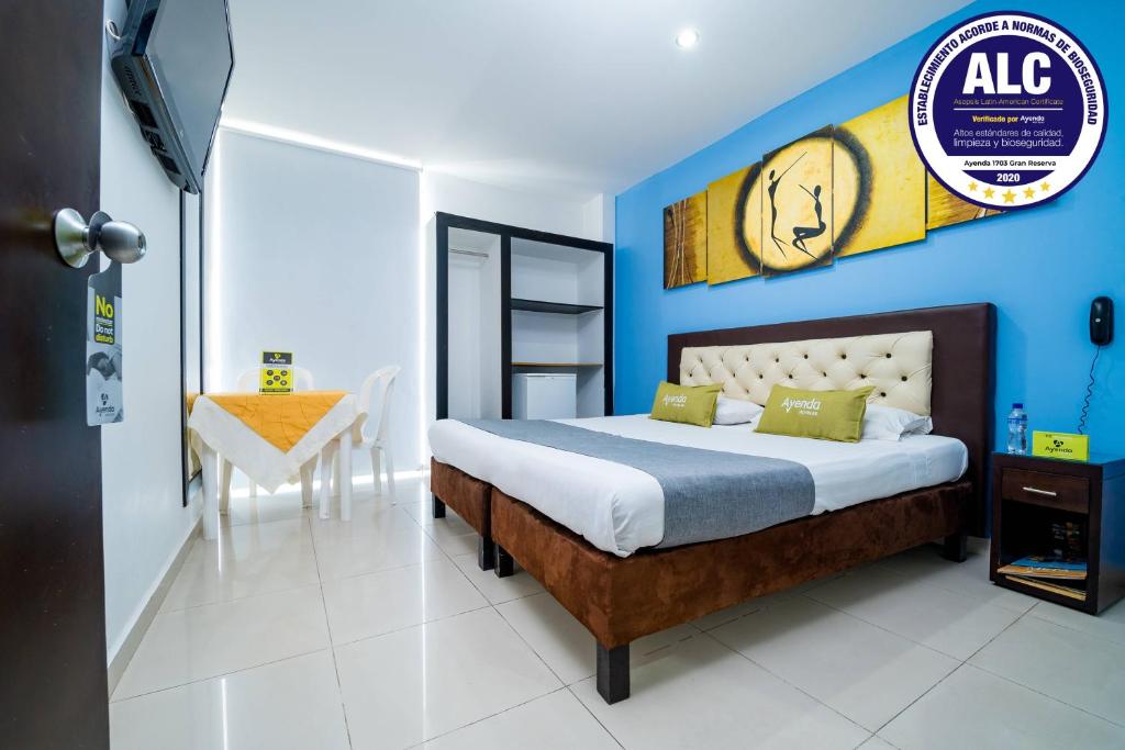 una camera con un letto con una parete blu di Ayenda 1703 Gran Reserva a Villavicencio