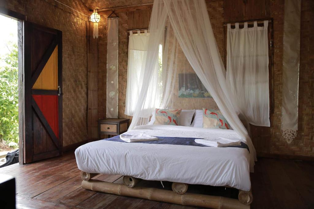 un dormitorio con una cama con dosel en Nongtao Homestay, en Ban Dong Than