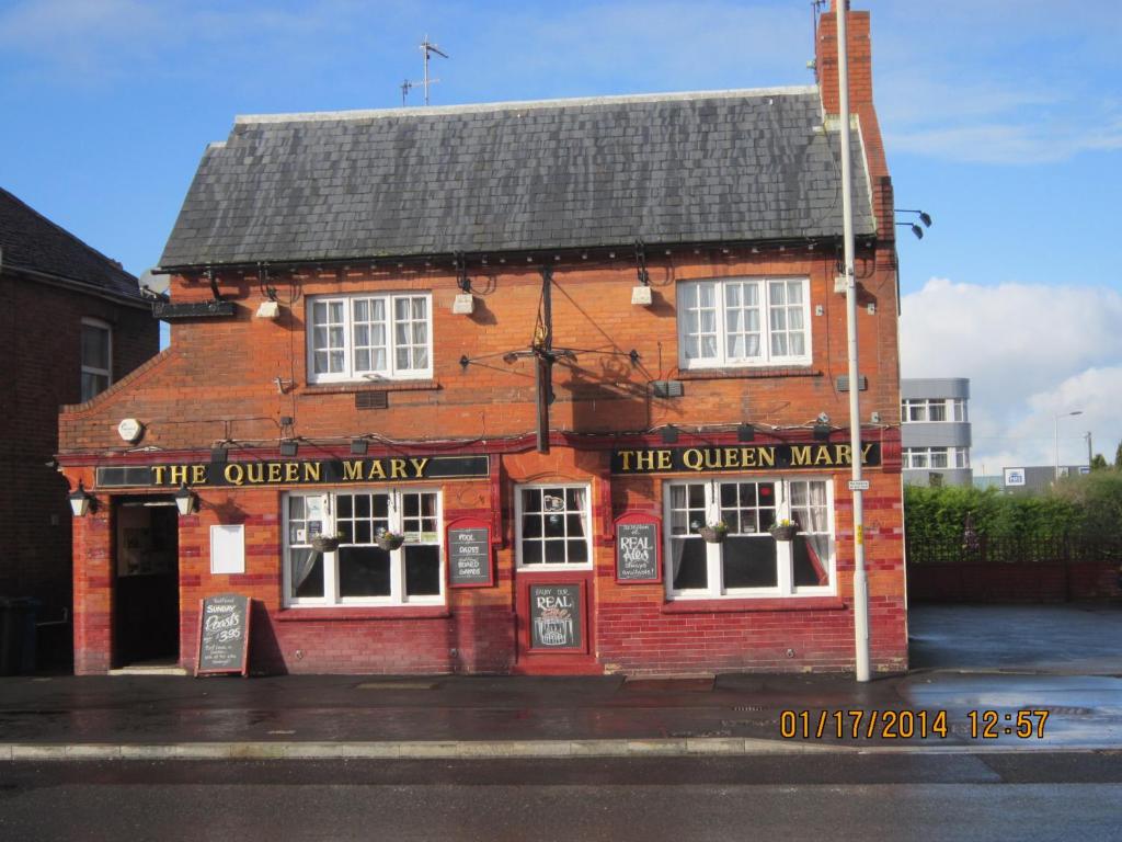 un edificio de ladrillo rojo con la manera reina en Queen Mary Inn, en Poole