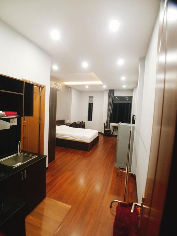 a room with a bed and a kitchen with a sink at xh apartment in Danang