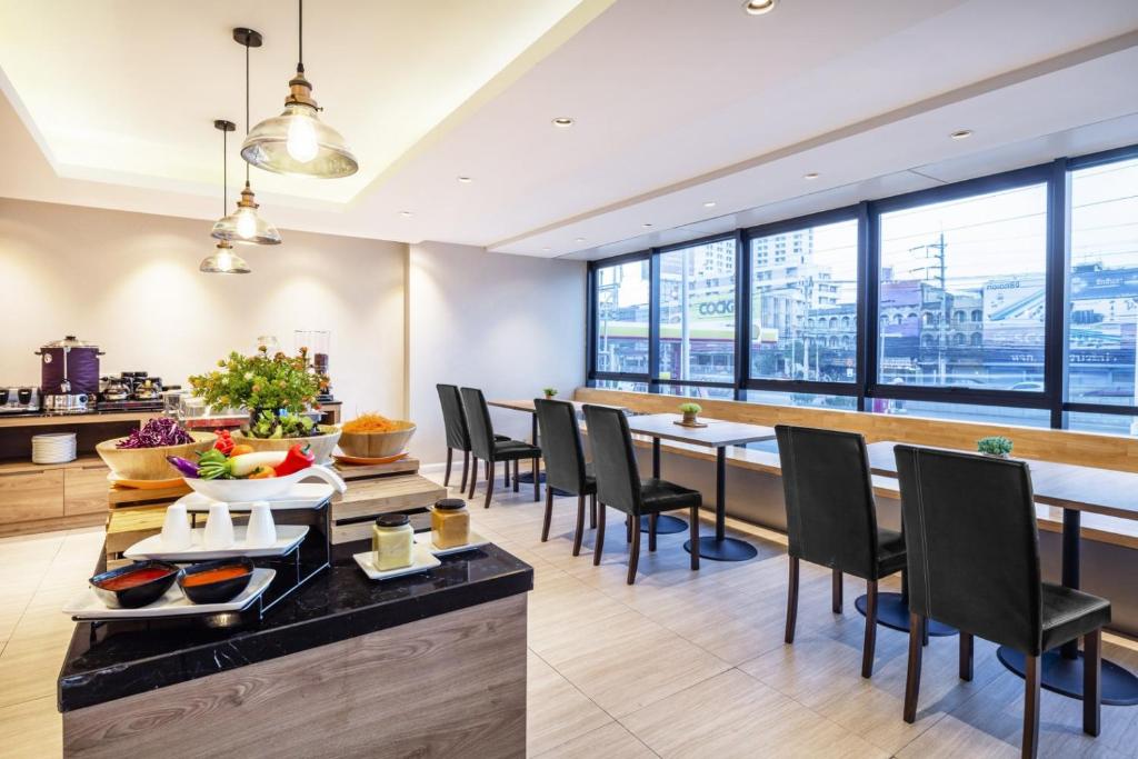 A breakfast room with buffet dishes, a communal counter and a long window-side table.