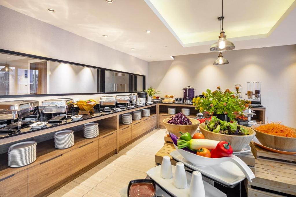 A close view of the breakfast buffet with hot dishes, plates, fruit and salad ingredients.