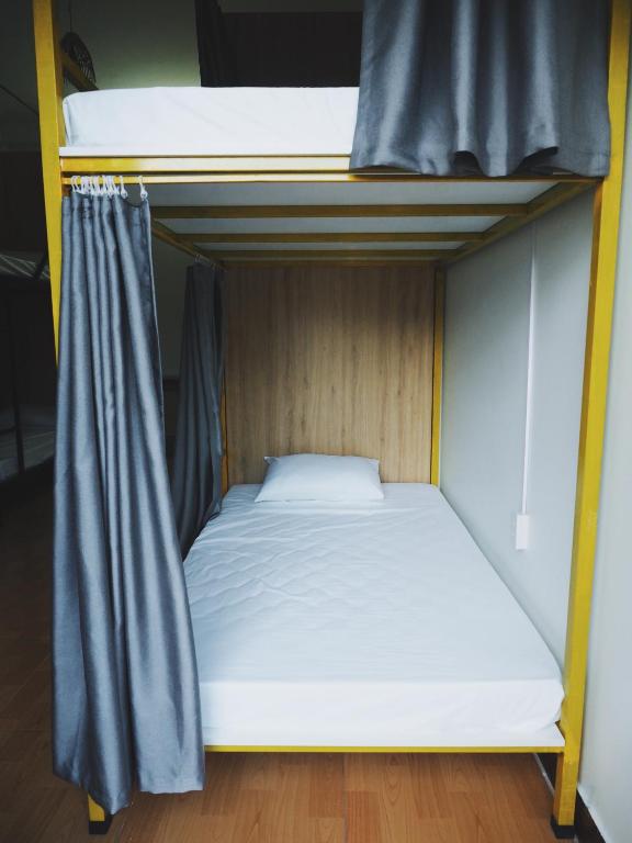 a bedroom with two bunk beds with white sheets at Be's Home & Tours in Ha Giang