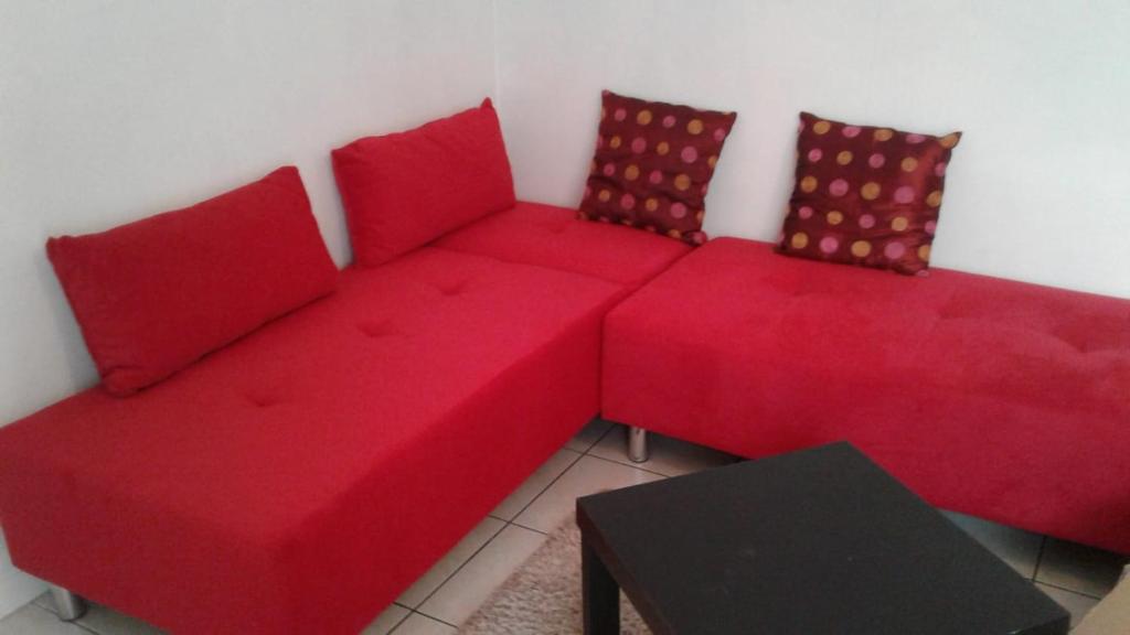 a red couch and two red chairs in a room at Foreword House in Albert