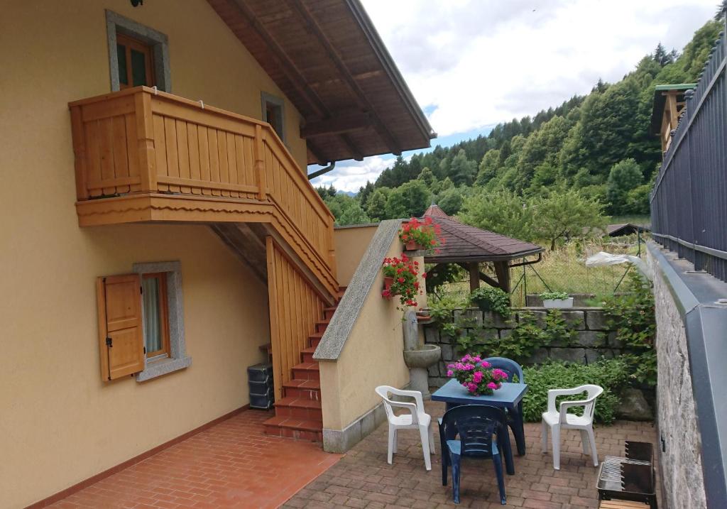 a patio with a table and chairs and a balcony at Casa Chiocciola CIPAT O22138-AT-O66928 in Pelugo