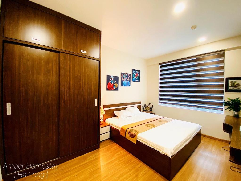 a bedroom with a bed and a large window at Amber Homestay Hạ Long in Ha Long