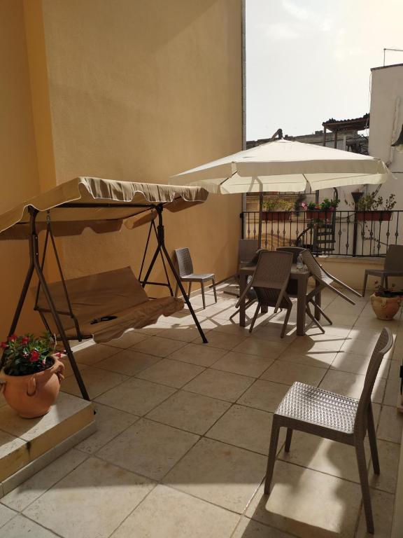 patio con letto, tavolo e ombrellone di Il Vicoletto ad Avetrana