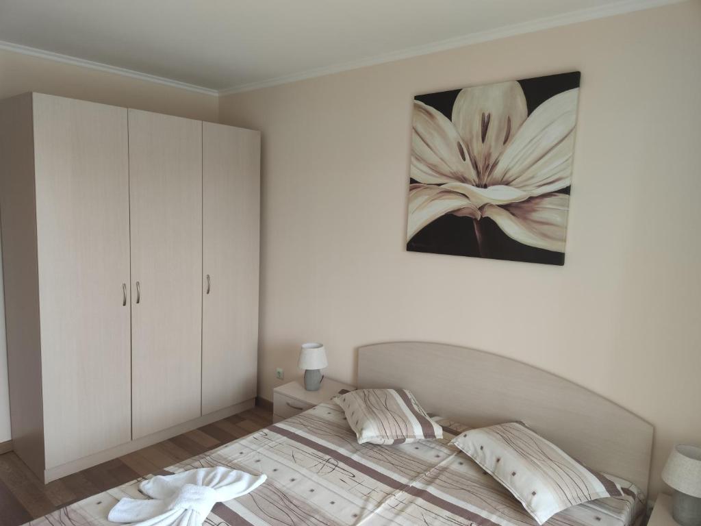 una camera da letto con un letto e un dipinto sul muro di Europroperties Riviera Park a Golden Sands