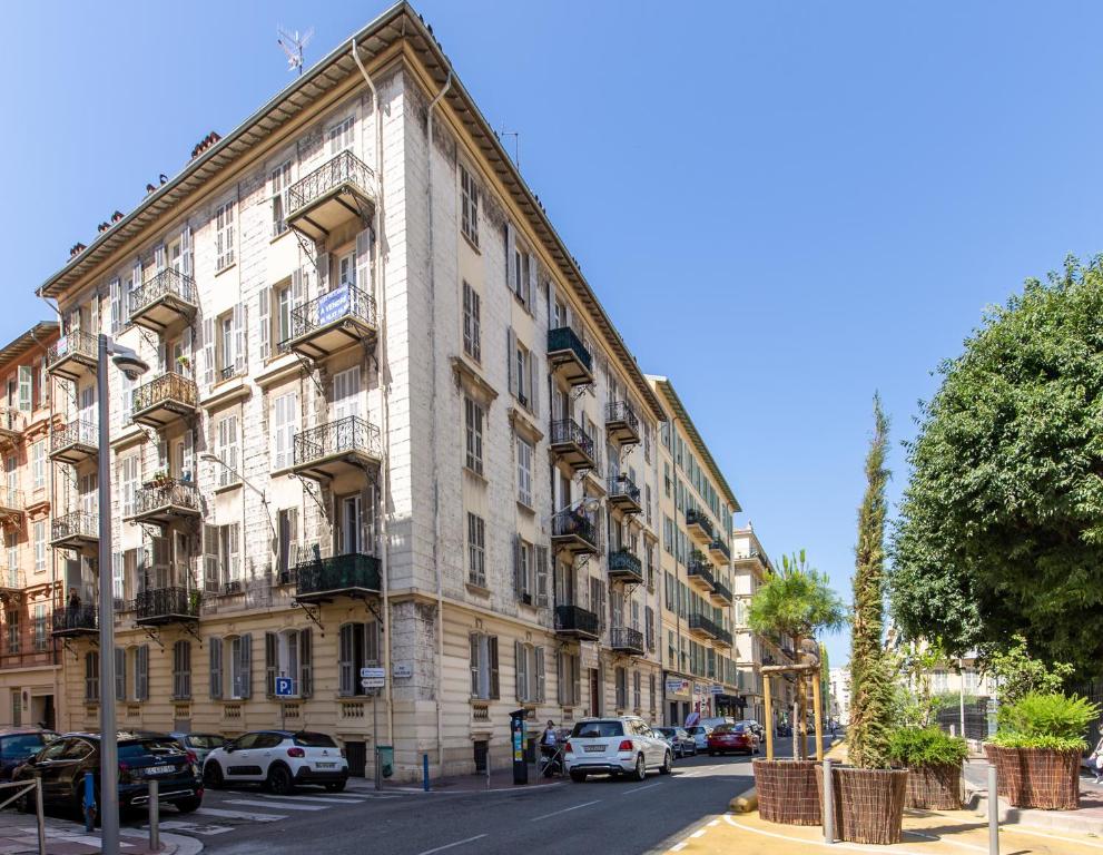 duży budynek z samochodami zaparkowanymi przed nim w obiekcie Apartment on Dante street next to the sea w Nicei