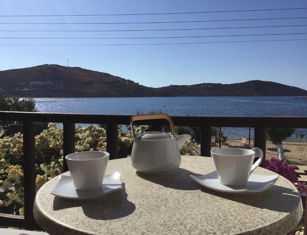 two cups and saucers on a table with a view of the water at Asteri Hotel in Livadi