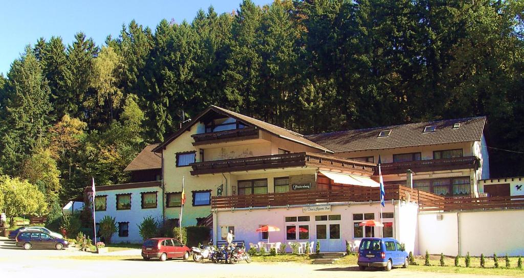 un gran edificio con coches estacionados frente a él en Hotel Finkenberg, en Blankenheim