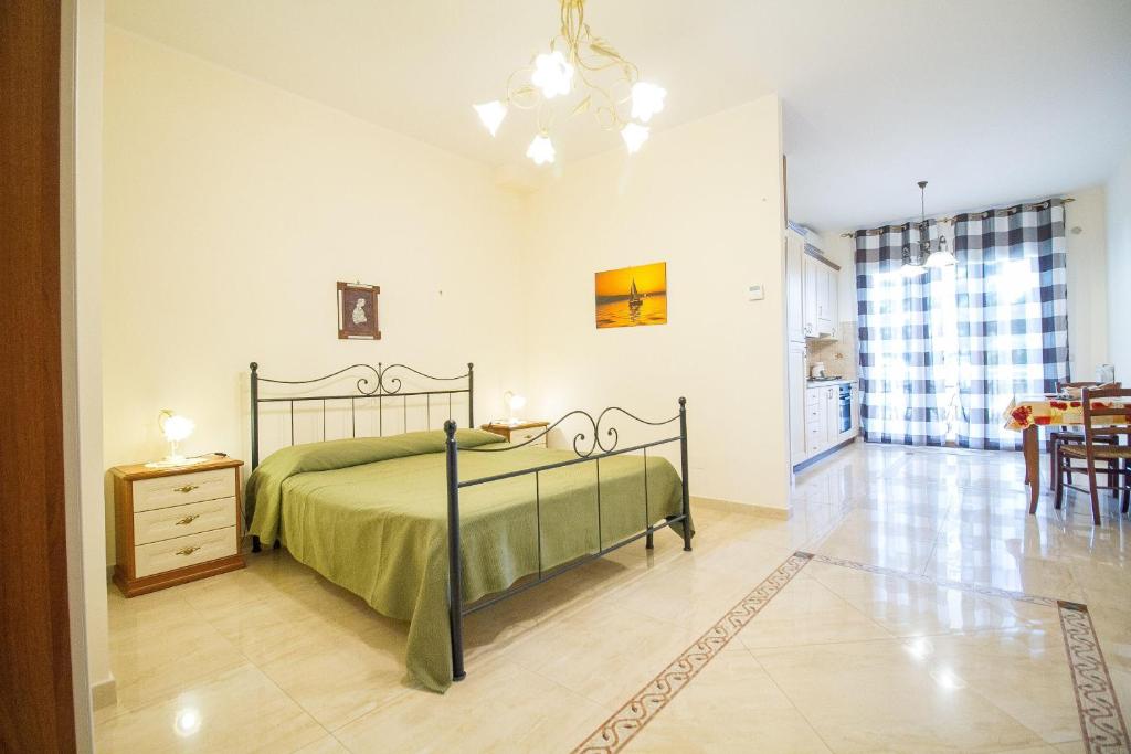 a bedroom with a green bed and a dining room at Etna-Royal-View-Appartamento-Monolocale-Vista-Mare in Trecastagni