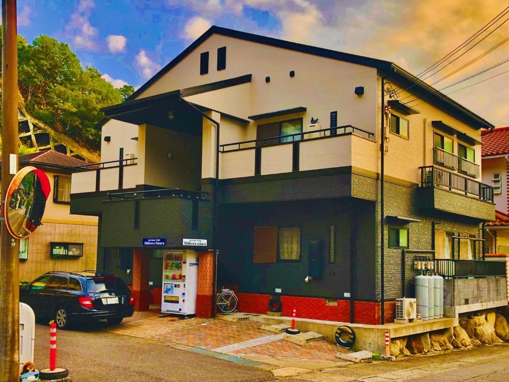 a house with a car parked in front of it at Midtown Sakura Apartment House 202 予約者だけの空間 A space just for you in Nachikatsuura