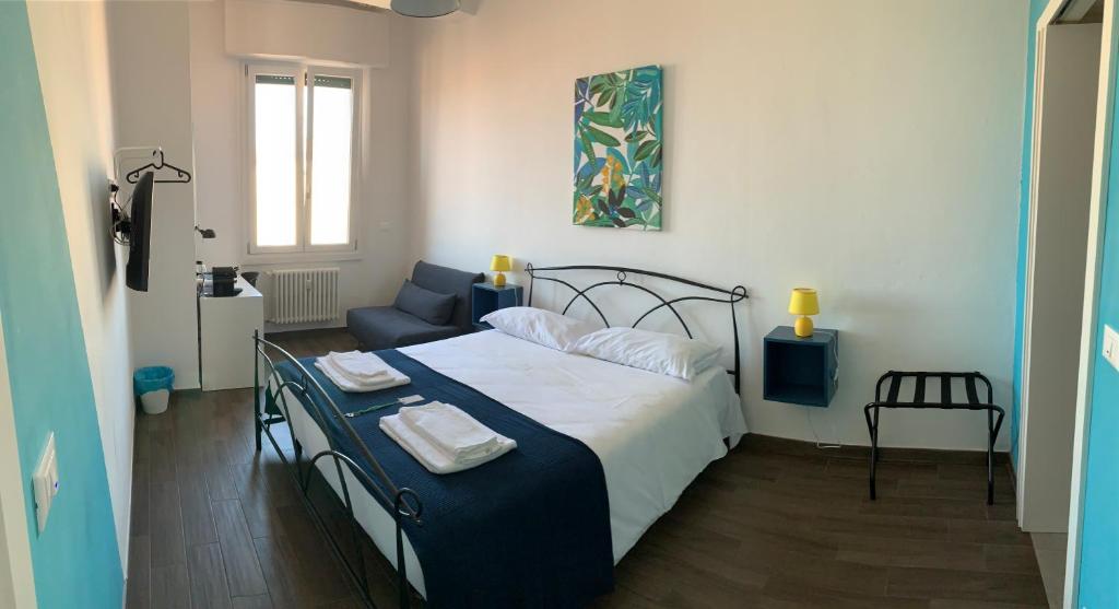 um quarto com uma cama e uma cadeira azul em Mambo Suites em Bolonha