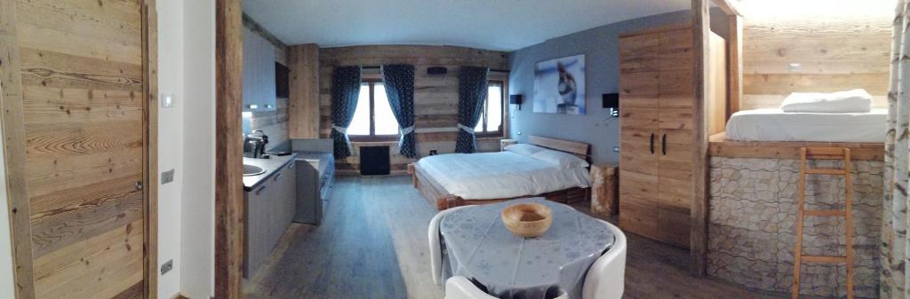 a bedroom with two beds and a bathroom with a sink at FIOCCO DI NEVE in Vezza dʼOglio