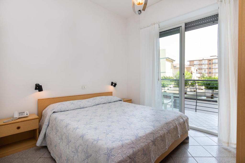 a bedroom with a bed and a large window at San Francisco rooms in Marina dʼAndora