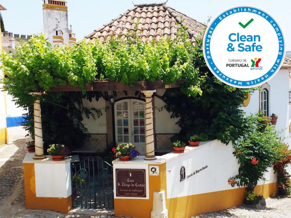 a sign that says clean and safe in front of a building at Casa de S. Thiago do Castelo in Óbidos