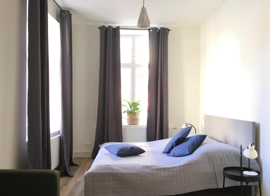 a bedroom with a bed with blue pillows and a window at Studios am Kniepertor in der Altstadt in Stralsund