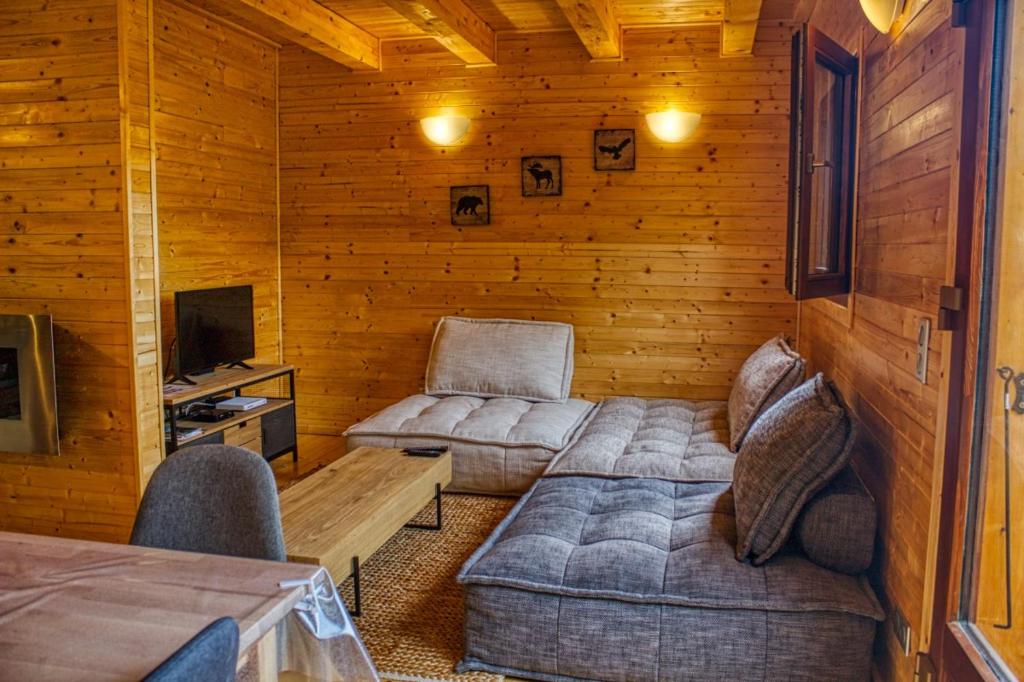 a living room with a couch and chairs in a cabin at Le chalet de Magali in Briançonnet