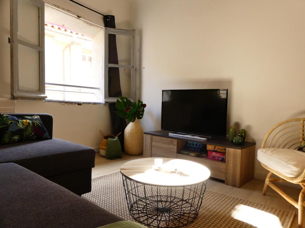 a living room with a couch and a tv at LE BEDARRIDE in Aix-en-Provence