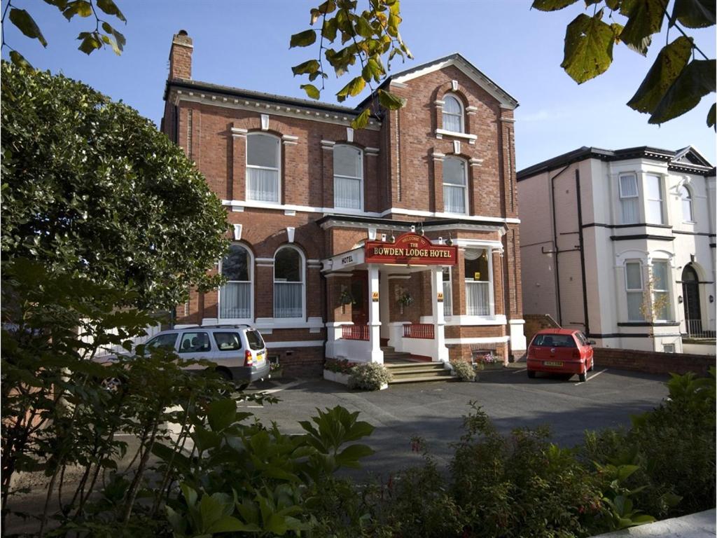 a brick building with cars parked in front of it at The Bowden Lodge in Southport