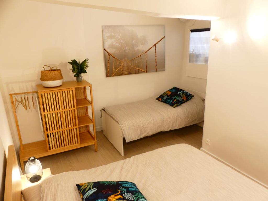 a small room with two beds and a window at LE BEDARRIDE in Aix-en-Provence