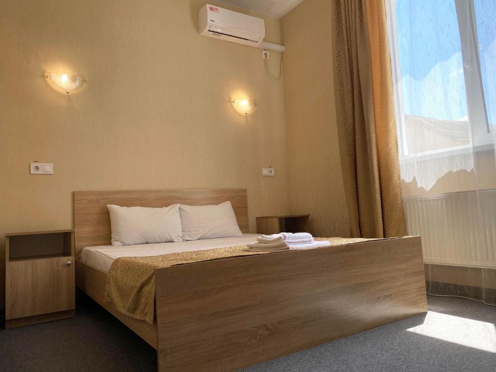 a bedroom with a bed with a large window at Guest House SOTNI in Kyiv