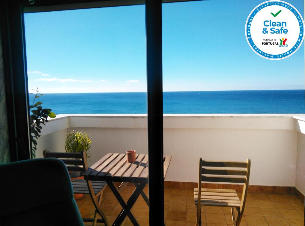un tavolo e sedie su un balcone con vista sull'oceano di Quarteira, Casa com Vista Mar a Quarteira