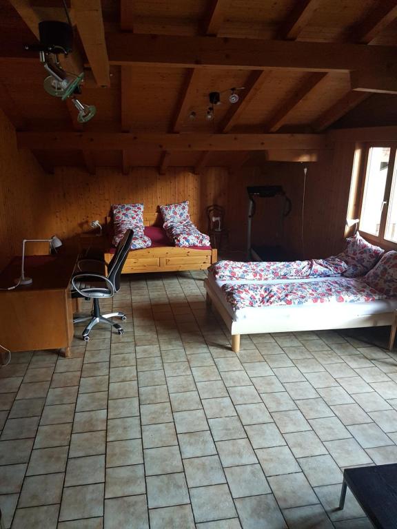 sypialnia z 2 łóżkami, biurkiem i krzesłem w obiekcie Apartment in Brienz w mieście Brienz