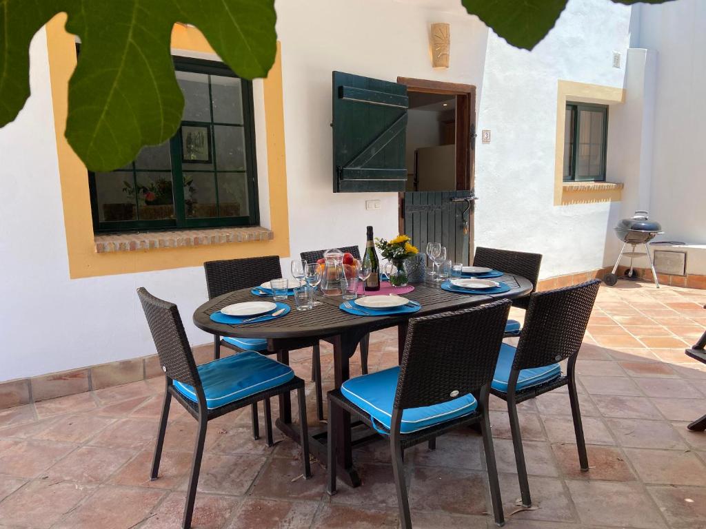 a dining room table and chairs with plates and glasses at Padre Aviles in Olías