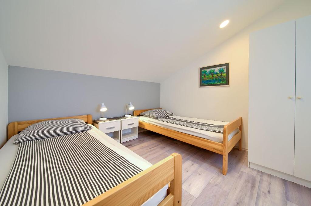 sypialnia z 2 łóżkami i szafką nocną oraz łóżko sidx sidx sidx sidx w obiekcie Apartment Milena by El-Pi Tours w mieście Nijvice