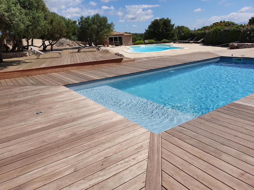 una piscina con terraza de madera y 2 piscinas en Résidence Canava en Bonifacio