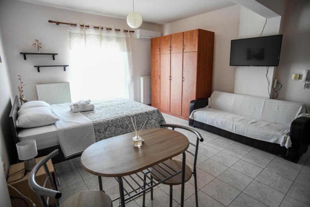 Zimmer mit einem Bett, einem Tisch und einem Sofa in der Unterkunft Papi's Free Parking Apartments 2 - Studio in Alexandroupoli