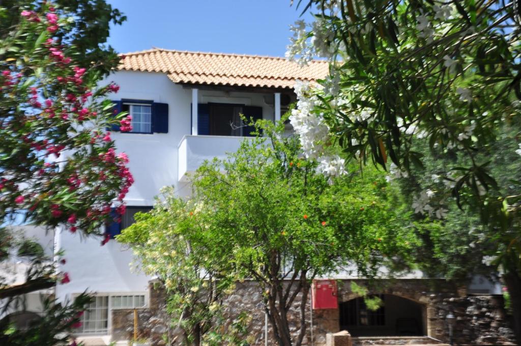 a white building with trees in front of it at Ifigenia's Apartments in Stoupa
