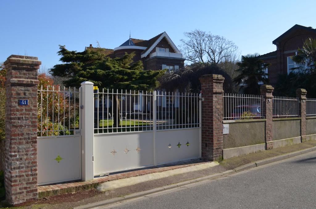 une clôture blanche avec un portail devant une maison dans l'établissement Stella Etretat, à Étretat