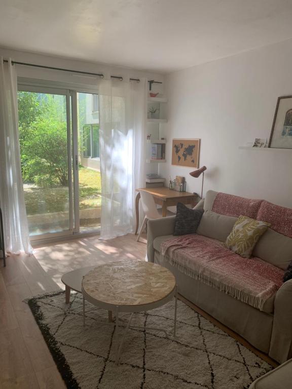 un salon avec un canapé et une table dans l'établissement T2 cosy 70s, à Avignon