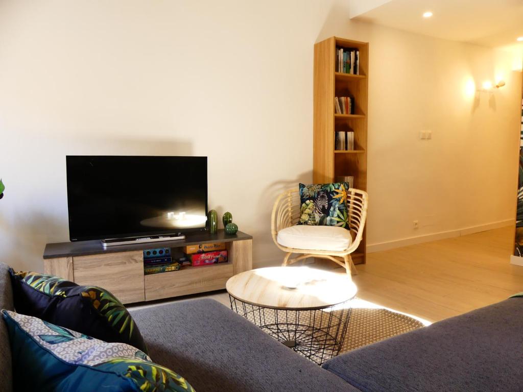 a living room with a couch and a flat screen tv at LE BEDARRIDE in Aix-en-Provence