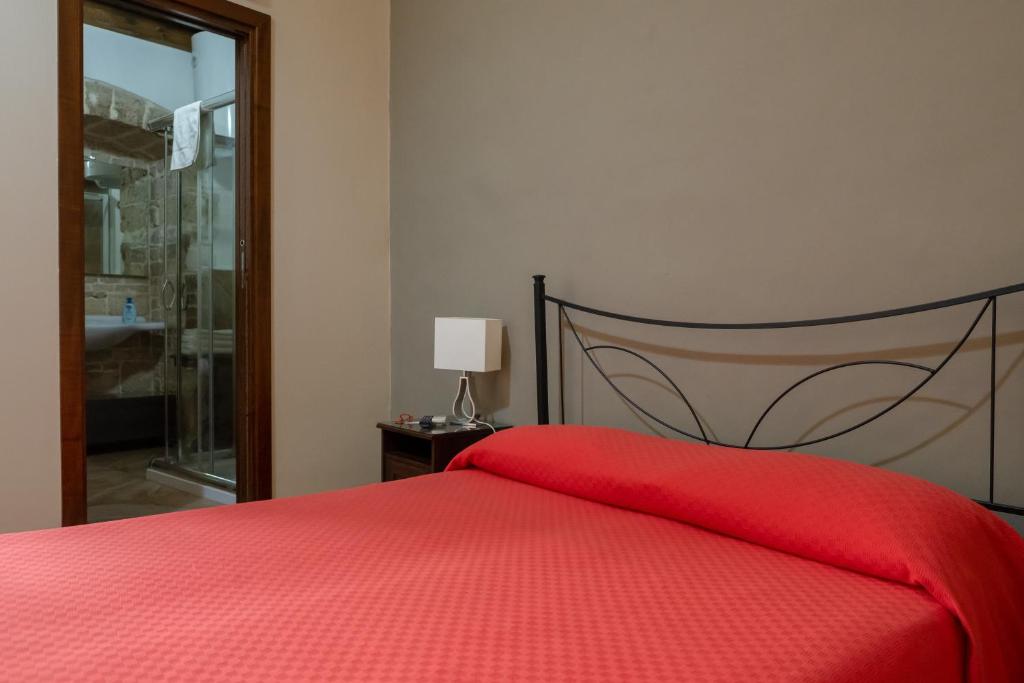 a bedroom with a red bed with a red blanket at B&B Santi Medici in Bitonto