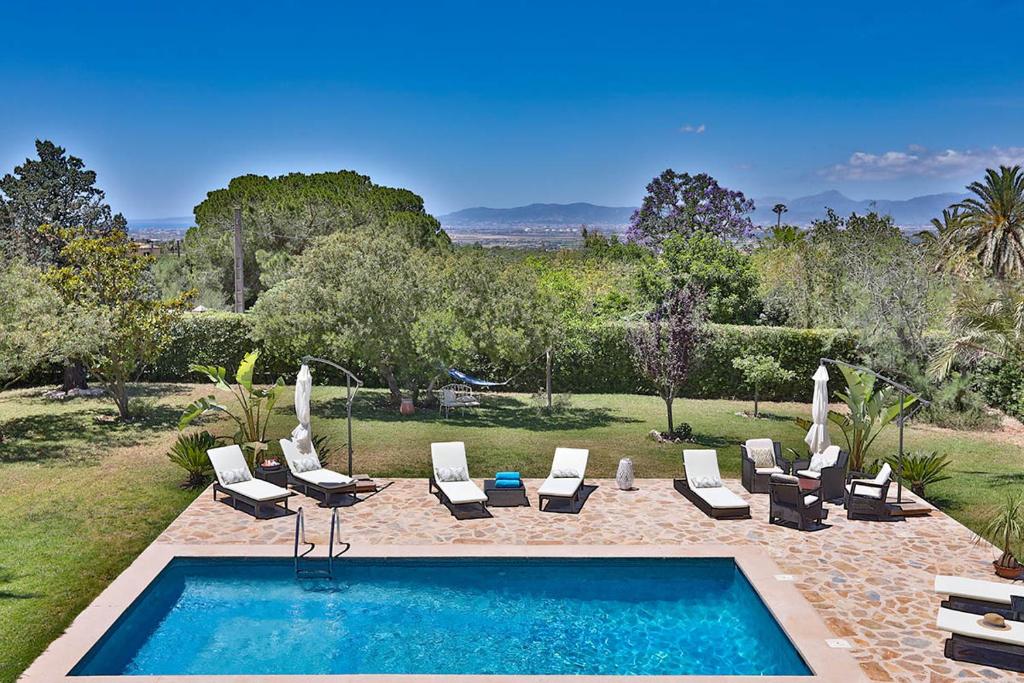 una piscina con tumbonas y una piscina en Villa Kentia, charming and stylish country house close to Palma, sleep 8, en Palma de Mallorca